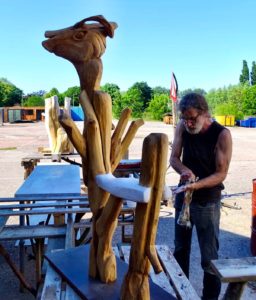 Jan Mostert werkt buiten aan een sculpture